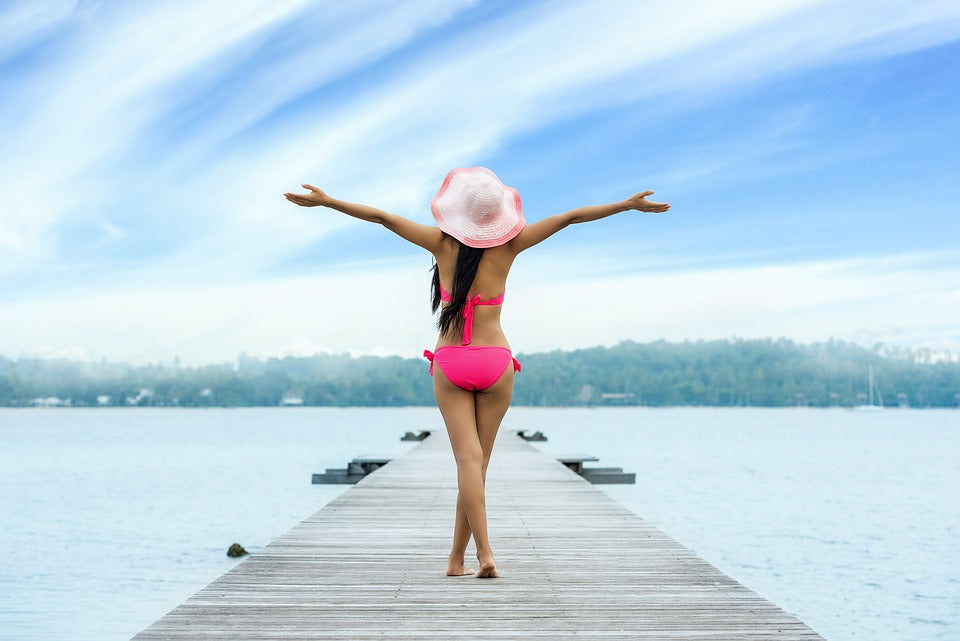 Jeune femme en maillot de bain sur ponton donnant sur l'océan