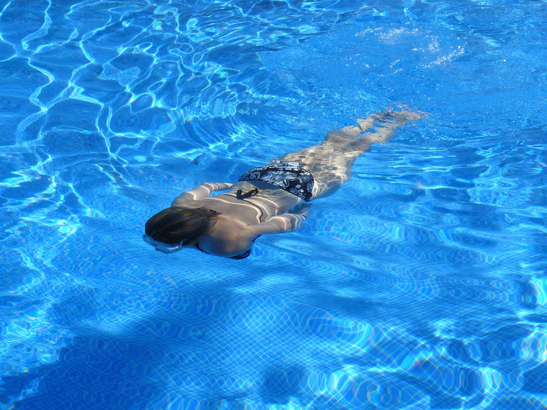 Jeune femme nageant dans une piscine